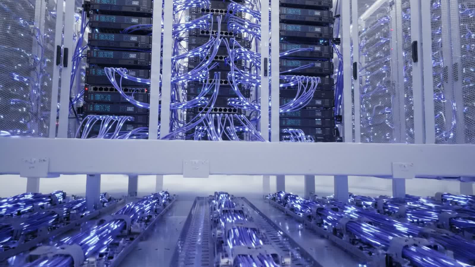 Veri merkezinde mavi ışıklarla aydınlanan sunucu kabinleri ve ağ kabloları